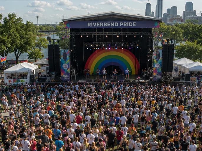 A festival crowd in front of the Riverbend Pride main stage on a summer afternoon